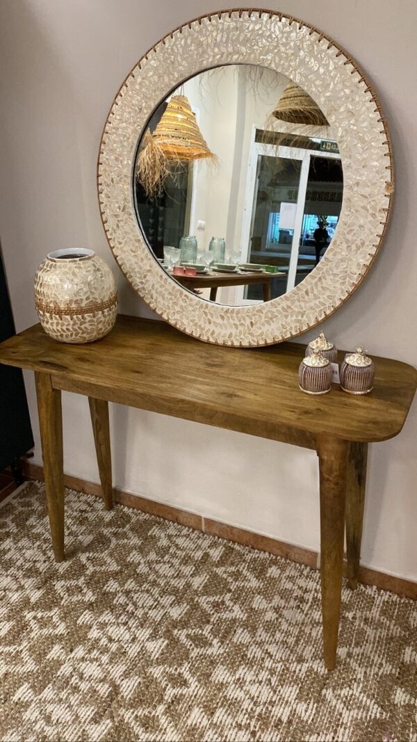 Mesa de madera de mango sobre alfombra en tonos claros y un espejo encima